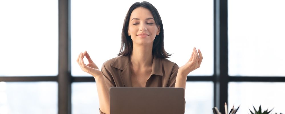 Kobieta medytująca w pozycji jogi - techniki relaksacyjne na redukcję stresu